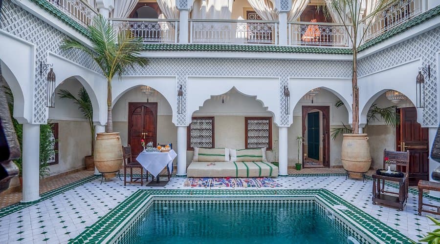 Cour intérieure d'un riad traditionnel marocain avec piscine en zellige